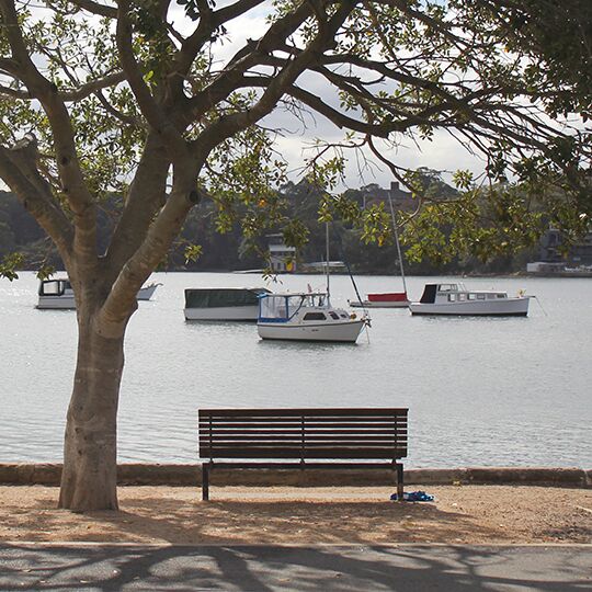  wooden street bench facing the water